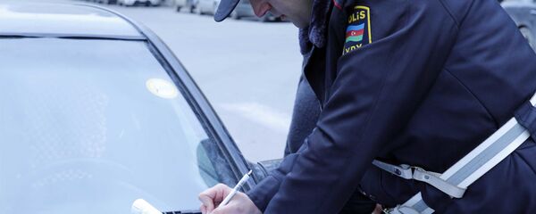 Сотрудник дорожной полиции составляет протокол об административном правонарушении, фото из архива Сотрудник дорожной полиции составляет протокол об административном правонарушении, фото из архива - Sputnik Азербайджан