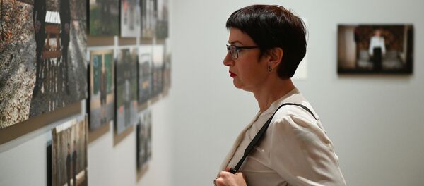 Посетительница на открытии выставки победителей IV международного конкурса фотожурналистики имени Андрея Стенина в Москве - Sputnik Азербайджан