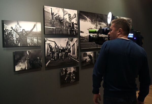 Посетитель на открытии выставки победителей IV международного конкурса фотожурналистики имени Андрея Стенина в Москве - Sputnik Азербайджан