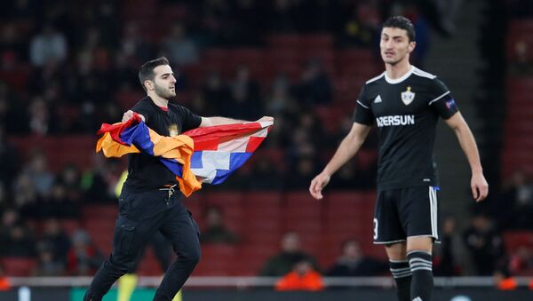 Болельщик Арсенала с флагом выбежал на поле во время игры азербайджанского клуба в Англии  - Sputnik Азербайджан