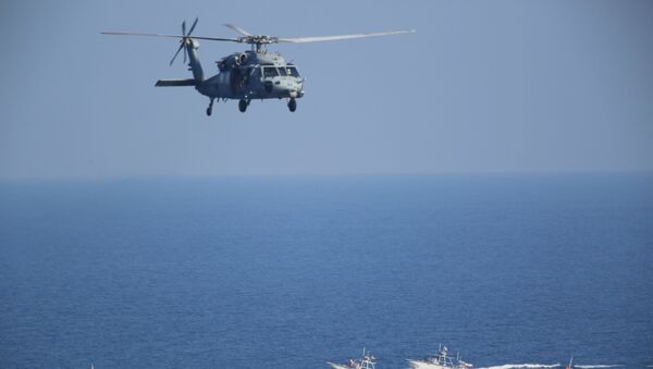 Amerikanın MH-60 Seahawk helikopteri Fars körfəzində İranın gözətçi gəmilərinin üzərindən üçür - Sputnik Azərbaycan