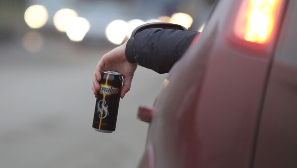 Мужчина пьет энергетический напиток за рулем автомобиля - Sputnik Azərbaycan