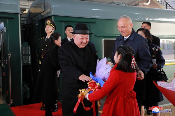 Лидер КНДР Ким Чен Ын получает цветы на железнодорожном вокзале Пекина - Sputnik Азербайджан