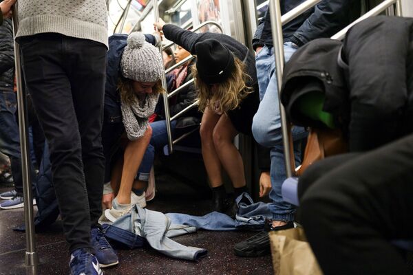 Женщины -участницы флешмоба В метро без штанов в вагоне поезда метро Нью-Йорка - Sputnik Азербайджан