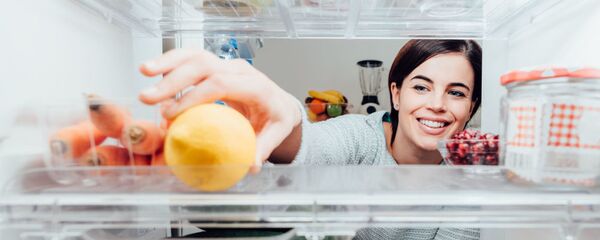 Девушка кладет продукты в холодильник - Sputnik Азербайджан