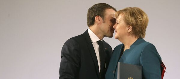 Президент Франции Эммануэль Макрон и канцлер Германии Ангела Меркель пожимают друг другу руки после подписания договора о французско-германской дружбе в ратуше Ахена, западная Германия - Sputnik Азербайджан