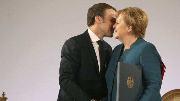 Президент Франции Эммануэль Макрон и канцлер Германии Ангела Меркель пожимают друг другу руки после подписания договора о французско-германской дружбе в ратуше Ахена, западная Германия - Sputnik Азербайджан