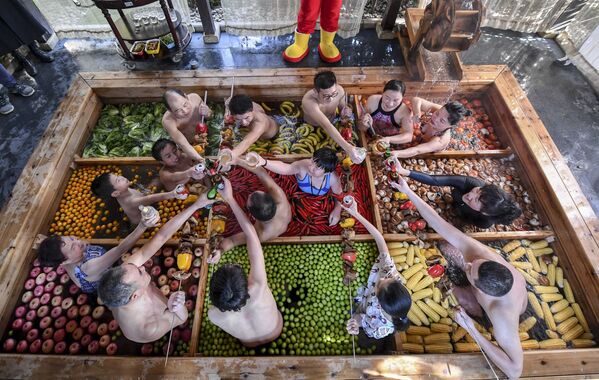 Постояльцы отеля в китайском городе Ханчжоу проводят время в теплом бассейне, наполненном фруктами и овощами, в предверии Китайского Нового года - Sputnik Азербайджан
