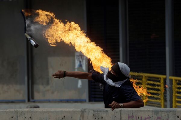 Демонстрант кидает бутылку с зажигательной смесью во время протестов против президента Гондураса Хуана Орландо Эрнандеса в Тегусигальпе - Sputnik Азербайджан