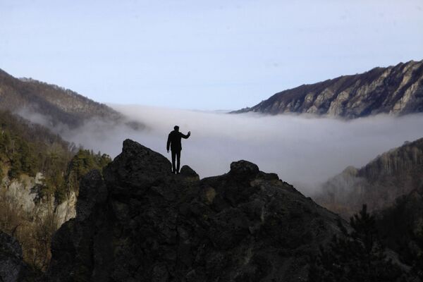 Турист фотографирует туман в ущелье горного склона Галанчожского района Чеченской республики - Sputnik Азербайджан