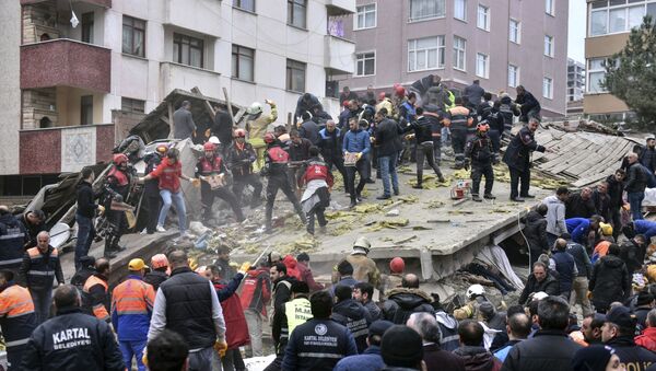 Спасатели и люди пытаются убрать обломки восьмиэтажного здания, которое рухнуло в среду в Стамбуле в среду, 6 февраля 2019 года - Sputnik Азербайджан