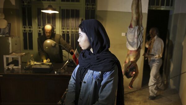 Посетительница музея в бывшей тюрьме, управляемой дореволюционной разведывательной службой, Савак, где выставлены восковые манекены следователей и заключенных - Sputnik Азербайджан