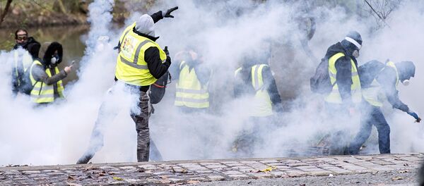 Демонстрант бросает дымовую гранату в ОМОН во время демонстрации протестующих Желтые жилеты (Gilets jaunes) в Нант, западная Франция - Sputnik Азербайджан