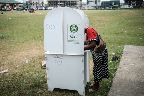 Женщина голосует на президентских и парламентских выборах на избирательном участке в Нигерии.  - Sputnik Азербайджан