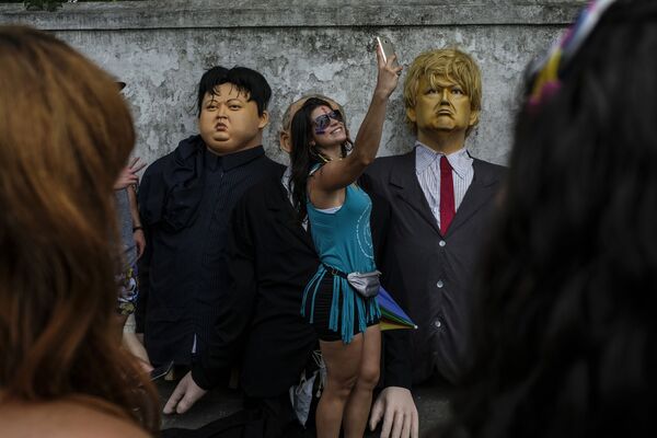 Девушка делает селфи рядом с куклами с президента США Дональда Трампа и северокорейского лидера Ким Чен Ына во время карнавальных торжеств в Олинде, Бразилия - Sputnik Азербайджан