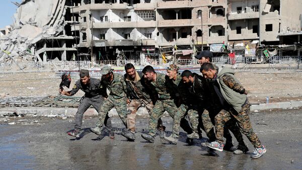 Бойцы сирийских демократических сил (SDF) танцуют на улице в Ракке, Сирия - Sputnik Азербайджан