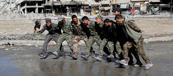Бойцы сирийских демократических сил (SDF) танцуют на улице в Ракке, Сирия - Sputnik Азербайджан