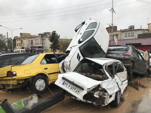 Перевернутые в результате наводнения автомобили в иранском городе Шираз - Sputnik Азербайджан