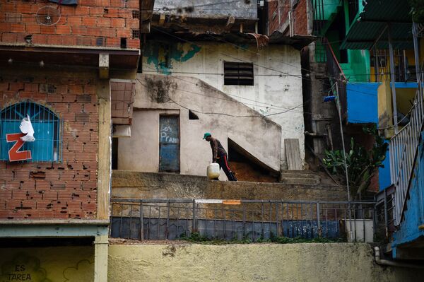 Местный житель несет канистры с водой, Каракас, Венесуэла - Sputnik Азербайджан