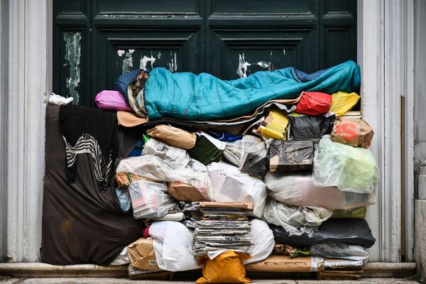 Бездомный спит на куче мусора под крыльцом в Риме, Италия - Sputnik Азербайджан