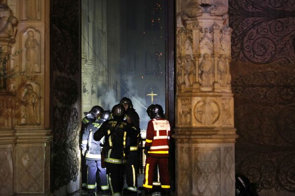 Пожарные во время тушения пожара в соборе Парижской Богоматери - Sputnik Азербайджан