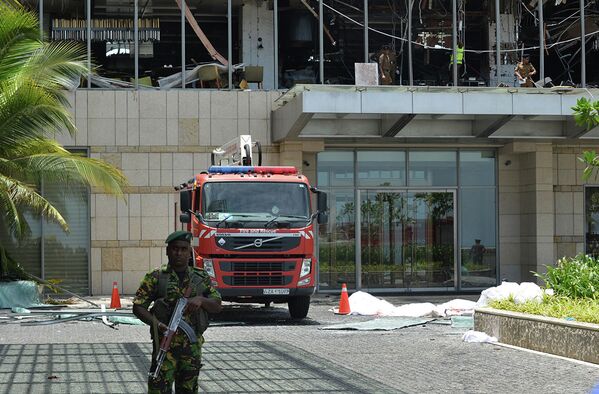 Сотрудник правоохранительных органов на месте взрыва в отеле Shangri-La в Коломбо - Sputnik Азербайджан