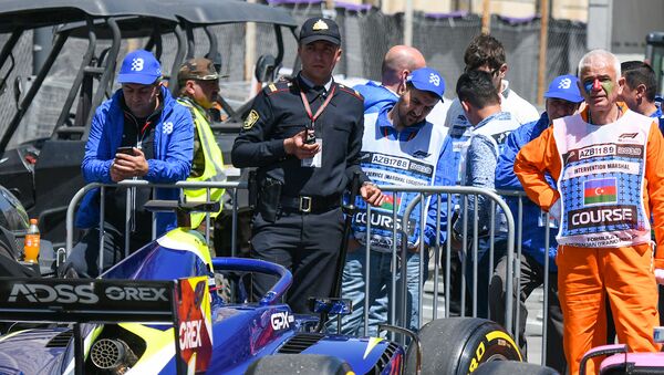 Полицейский рядом с болидом во время Гран при Азербайджана Формула 1 - Sputnik Азербайджан