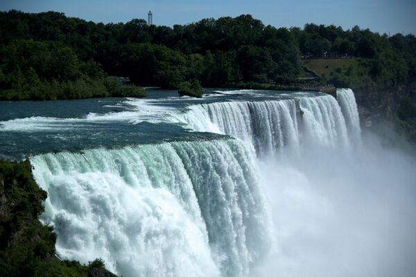 Ниагарский водопад - каскад водопадов на границе Америки и Канады. Водопад можно назвать самым эффектным естественным разломом земной коры. Река Ниагара, соединяющая озера Эри и Онтарио, падает с высоты 50-метрового обрыва шириной более километра - Sputnik Азербайджан