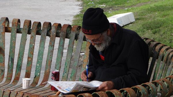 Мужчина в возрасте заполняет кроссворд в газете - Sputnik Азербайджан