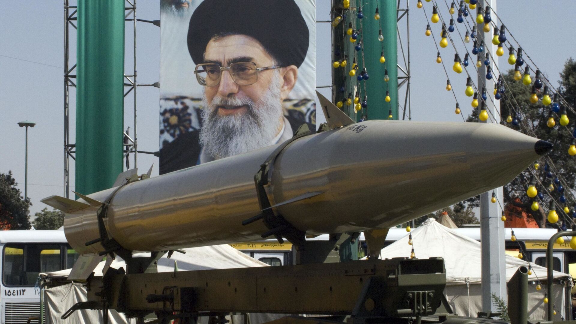 Ракета, перед плакатом верховного лидера Ирана аятоллы Али Хаменеи, во время военной выставки - Sputnik Азербайджан, 1920, 29.05.2022