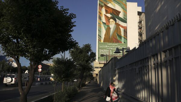 Женщина проходит мимо росписи покойного основателя революции аятоллы Хомейни в Тегеране, Иран - Sputnik Азербайджан