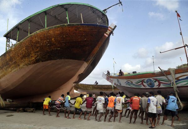 Индийские рыбаки вытаскивают на сушу корабль перед началом сезона муссонных дождей - Sputnik Азербайджан
