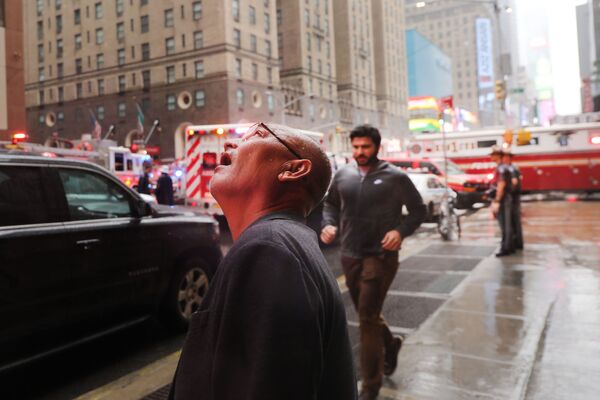 Мужчина наблюдает за местом падения вертолета на небоскреб в Нью-Йорке - Sputnik Азербайджан