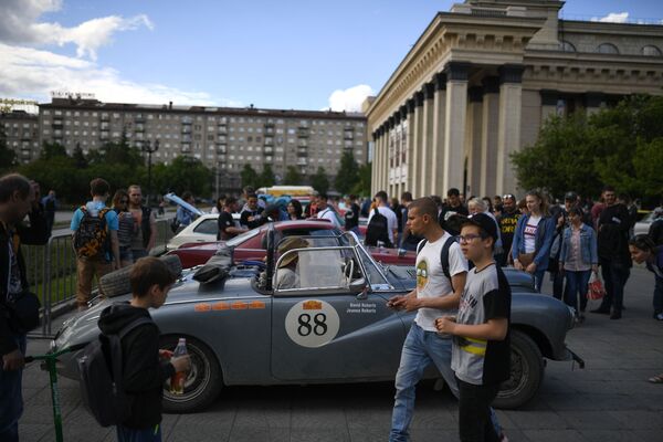 Участники международного ралли на старинных автомобилях Пекин - Париж 2019 на стоянке перед Театром оперы и балета в Новосибирске - Sputnik Азербайджан