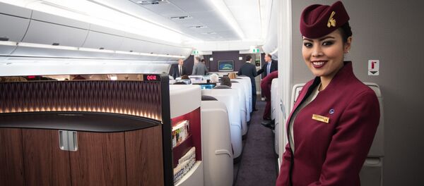 Стюардесса Qatar Airways улыбается пассажирам - Sputnik Азербайджан