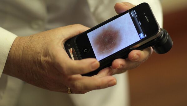 Доктор Антонелла Тости, дерматолог Медицинского факультета Университета Майами, отображает на своем телефоне изображение мелономы пациента - Sputnik Азербайджан