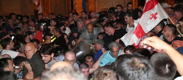 Полицейские пытаются заблокировать протестующих во время митинга против визита российской делегации возле здания парламента в Тбилиси, Грузия - Sputnik Азербайджан