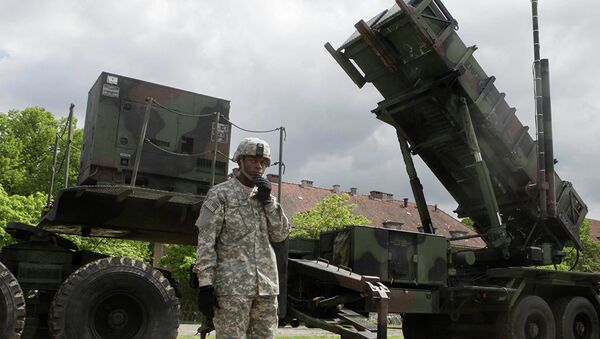 Американский военный стоит рядом с зенитно-ракетным комплексом Patriot на военной базе в Мораге, Польша - Sputnik Azərbaycan