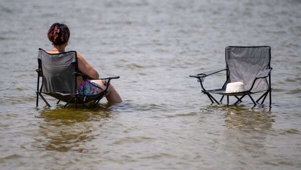 Женщина из-за жары сидит в кресле на озере Ваназее в Берлине - Sputnik Azərbaycan