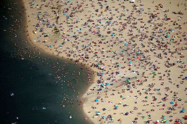 Отдыхающие на пляже города Хальтерн-ам-Зе в сезон сильной жары в Германии - Sputnik Азербайджан