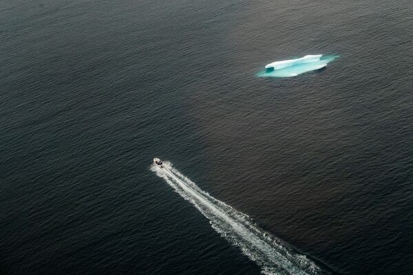 Катер проходит мимо айсберга в открытом океане возле Тасиилака, Гренландия - Sputnik Азербайджан