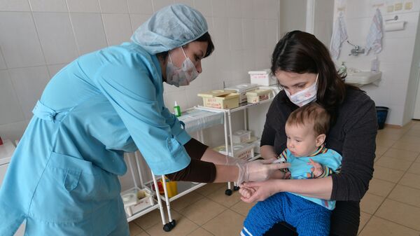 Медсестра делает прививку ребенку в детской поликлинике - Sputnik Azərbaycan