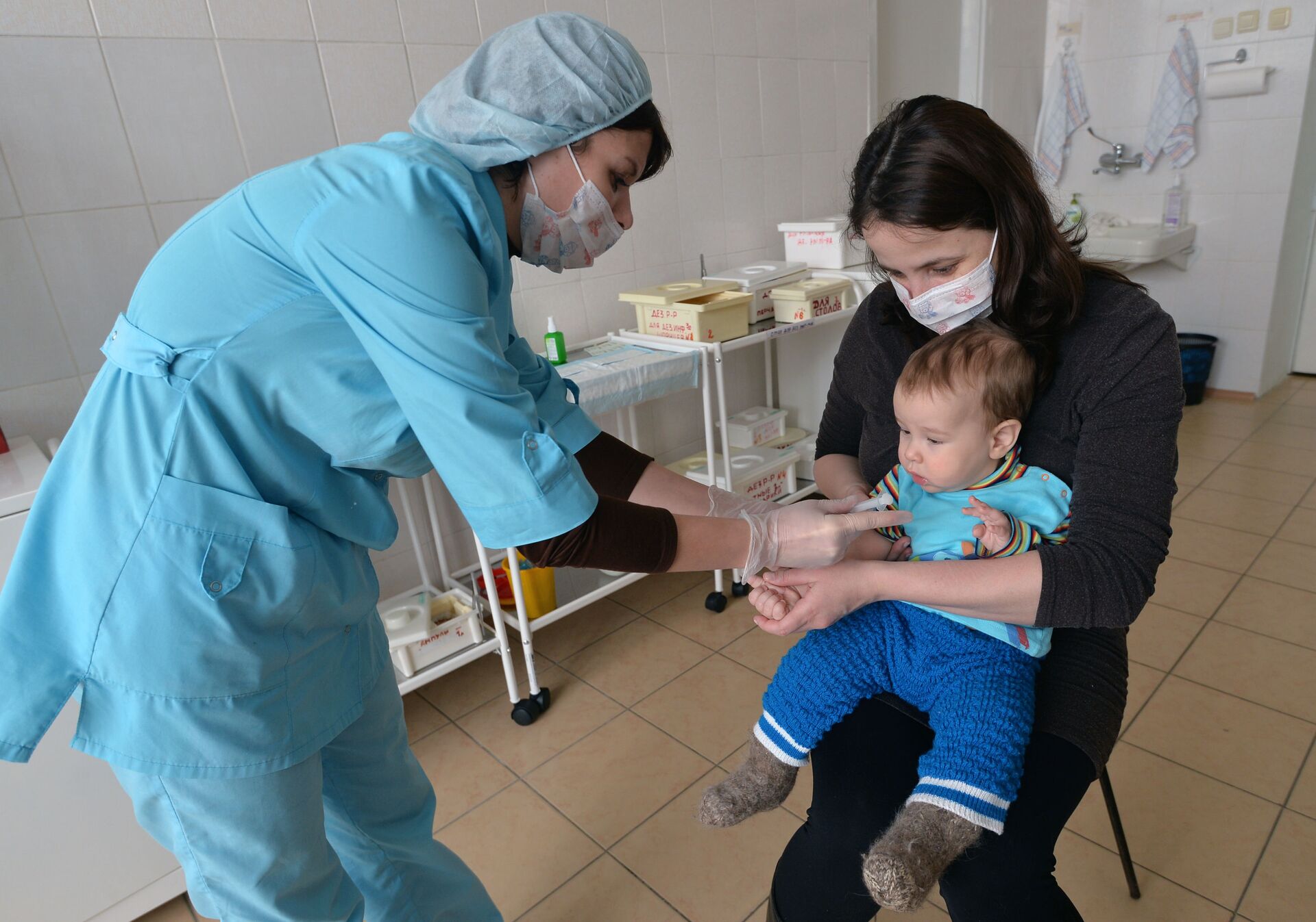 Медсестра делает прививку ребенку в детской поликлинике - Sputnik Azərbaycan, 1920, 07.12.2022