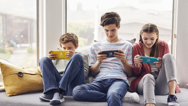 Трое подростков играют в новую приставку Nintendo Switch Lite - Sputnik Азербайджан