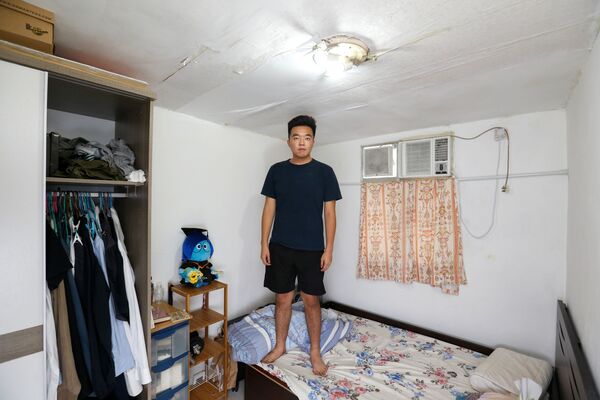 23-летний уроженец Гонконга Рой Лам, кадровый специалист, живущий с матерью и четырьмя сестрами, в своей спальне площадью 7 кв. м - Sputnik Азербайджан