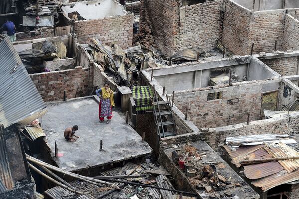 Ребенок играет на крыше сгоревшего дома в трущобах Дакки, Бангладеш - Sputnik Азербайджан