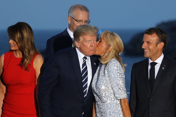 Жена президента Франции Брижит Макрон целует президента США Дональда Трампа во время совместного фотографирования на саммите G7 в Биаррице - Sputnik Азербайджан