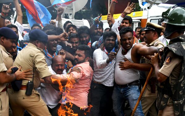 Члены Конгресса Карнатаки во время столкновений с полицией во время протеста против премьер-министра Индии Нарендры Моди и министра внутренних дел Амита Шаха в Бангалоре - Sputnik Азербайджан