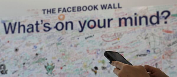 Женщина использует свой мобильный телефон в офисе Facebook в Дубае, Объединенные Арабские Эмираты, фото из архива - Sputnik Азербайджан