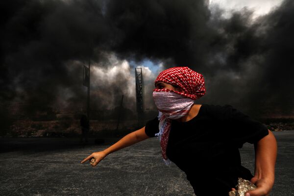 Палестинский демонстрант возле еврейского поселения Бейт-Эль на оккупированном Израилем Западном берегу - Sputnik Азербайджан